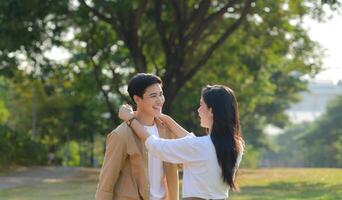 LGBT couple is enjoying a summer vacation in the park, happily showing their love to each other. photo