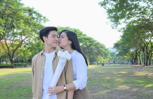 LGBT couple is enjoying a summer vacation in the park, happily showing their love to each other. photo