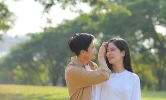 LGBT couple is enjoying a summer vacation in the park, happily showing their love to each other. photo