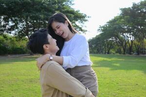 LGBT couple is enjoying a summer vacation in the park, happily showing their love to each other. photo