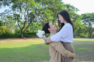 LGBT couple is enjoying a summer vacation in the park, happily showing their love to each other. photo