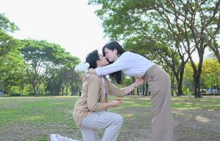 LGBT couple is enjoying a summer vacation in the park, happily showing their love to each other. photo