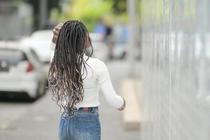 un joven mujer con su peinado y el atmósfera de vivo en el comunidad. foto