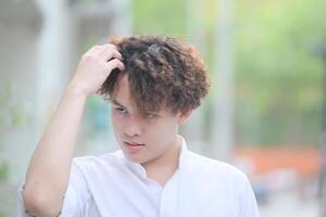 A young man with his hairstyle and the atmosphere of living in the community. photo