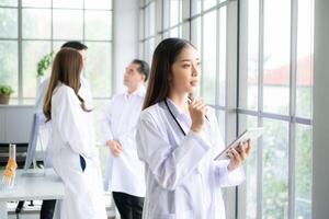 Portrait of female medical and team discuss a case study involving disease therapy for a hospital patient. photo