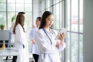 Portrait of female medical and team discuss a case study involving disease therapy for a hospital patient. photo