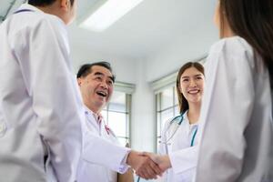 A delighted doctor team enjoying achievement in a hospital setting with high five. photo