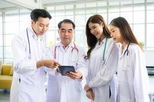 A medical professor and medical student discuss a case study involving disease therapy for a hospital patient. photo