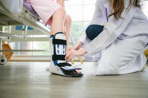 Following a period of treatment, the doctor examines the patient's legs and knees. photo