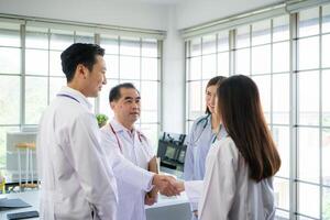 A delighted doctor team enjoying achievement in a hospital setting with high five. photo