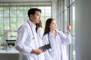 A team of medical discuss a case study involving disease therapy for a hospital patient. photo