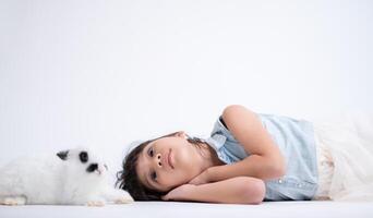 Smiling little girl and with their beloved fluffy rabbit, showcasing the beauty of friendship between humans and animals photo