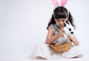 Smiling little girl and with their beloved fluffy rabbit, showcasing the beauty of friendship between humans and animals photo