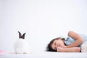 Smiling little girl and with their beloved fluffy rabbit, showcasing the beauty of friendship between humans and animals photo