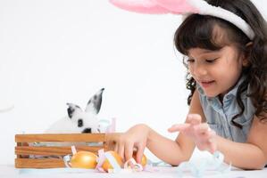 sonriente pequeño niña y con su amado mullido conejo, exhibiendo el belleza de amistad Entre humanos y animales foto