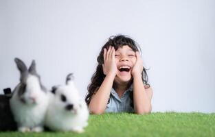 Smiling little girl and with their beloved fluffy rabbit, showcasing the beauty of friendship between humans and animals photo