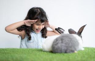 Smiling little girl and with their beloved fluffy rabbit, showcasing the beauty of friendship between humans and animals photo