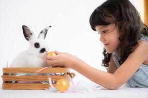 Smiling little girl and with their beloved fluffy rabbit, showcasing the beauty of friendship between humans and animals photo