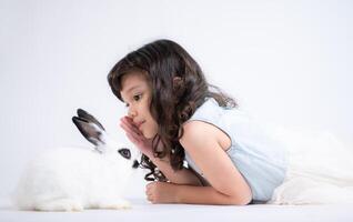 A little girl kisses her beloved fluffy rabbit, The beauty of friendship between humans and animals photo