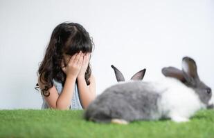 Smiling little girl and with their beloved fluffy rabbit, showcasing the beauty of friendship between humans and animals photo