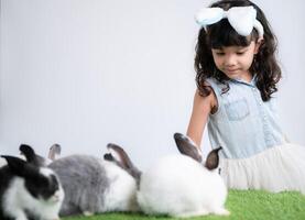 Smiling little girl and with their beloved fluffy rabbit, showcasing the beauty of friendship between humans and animals photo