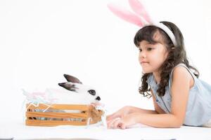 Smiling little girl and with their beloved fluffy rabbit, showcasing the beauty of friendship between humans and animals photo