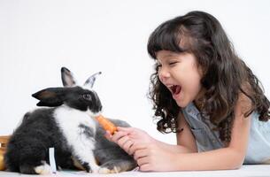 Smiling little girl and with their beloved fluffy rabbit, showcasing the beauty of friendship between humans and animals photo