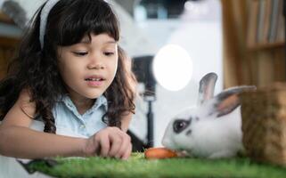 Smiling little girl and with their beloved fluffy rabbit, showcasing the beauty of friendship between humans and animals photo