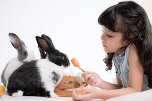 Smiling little girl and with their beloved fluffy rabbit, showcasing the beauty of friendship between humans and animals photo