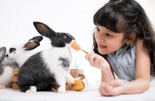 Smiling little girl and with their beloved fluffy rabbit, showcasing the beauty of friendship between humans and animals photo