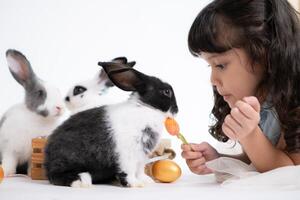 Smiling little girl and with their beloved fluffy rabbit, showcasing the beauty of friendship between humans and animals photo