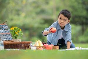 Happy family enjoying a picnic in the park, with children having fun sitting, surrounded by nature photo