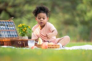 Happy family enjoying a picnic in the park, with children having fun sitting, surrounded by nature photo