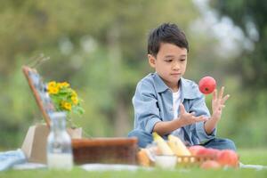 Happy family enjoying a picnic in the park, with children having fun sitting, surrounded by nature photo