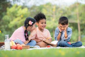 Happy family enjoying a picnic in the park, Children are having fun drawing on paper. photo