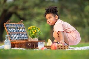 Happy family enjoying a picnic in the park, with children having fun sitting, surrounded by nature photo