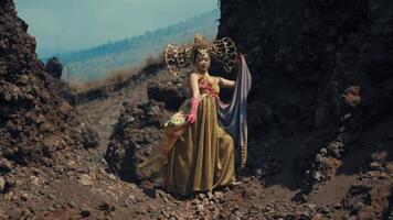mujer en elegante vestir posando con brazos extendido en un escabroso paisaje. video