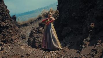 Woman in traditional dress posing between rocky cliffs. video