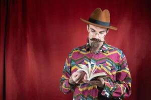 Vintage Hipster man with glasses, hat and mustache watching a book photo
