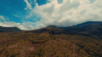 antenne visie van een weelderig berg landschap onder een dynamisch bewolkt lucht. video