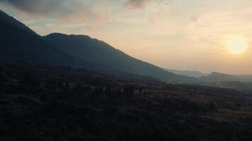 zonsondergang over- een sereen berg landschap met zacht licht en schaduwen, ideaal voor achtergronden of natuur thema's. video