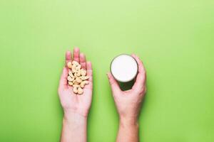 Female Hands Holds cashew nuts and glass of non diary milk photo