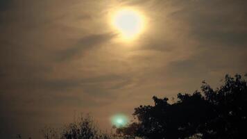 Mysterious evening sky with sun partially obscured by clouds, creating a dramatic atmosphere. video