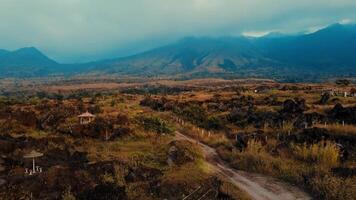 Scenic view of a countryside road leading towards distant mountains with lush greenery and cloudy skies. video
