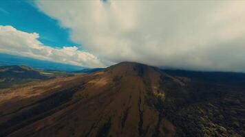 aereo Visualizza di un' vasto montagnoso paesaggio sotto un' drammatico cielo con nuvole. video