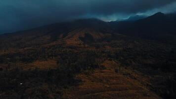 mistico paesaggio con scuro, lunatico montagne sotto nuvoloso cieli, evocando un' senso di Dramma e solitudine. video