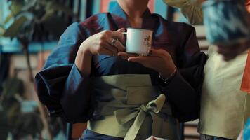 persona en tradicional japonés kimono participación un té taza, con un atención en el manos y el taza. video