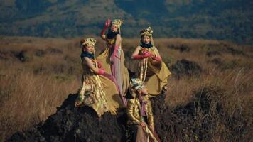 Traditional dancers in vibrant costumes performing in a natural landscape video