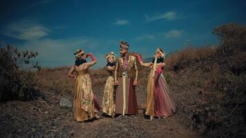 Two individuals in traditional attire walking on a mountain path under a clear sky. video