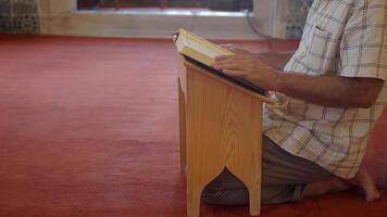 muslim man hand holding Holy book Quran at mosque video